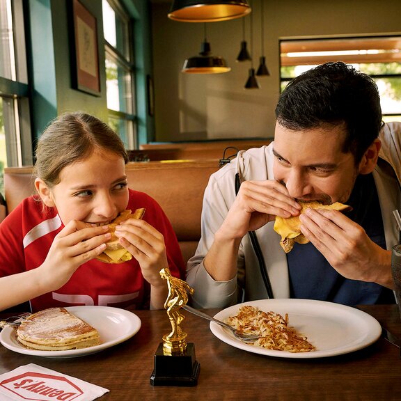 Father and daughter eating at Denny's