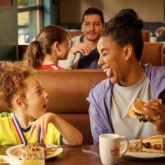 Mother and daughter eating at Denny's