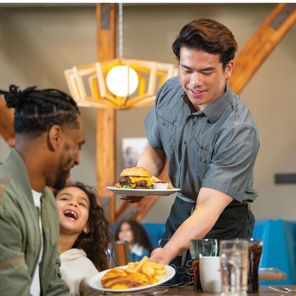 Denny's Server Bringing Food to a Table